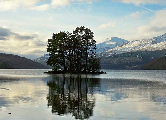 Loch Tay with Ben Lawers in the background, showcasing the dynamic landscape under a cloudy sky.

